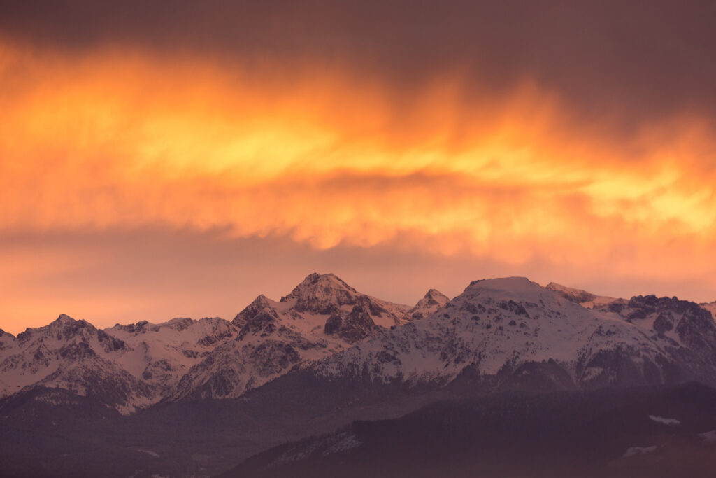 Sommets de montagnes proche de Grenoble enneigés avec couché de soleil en fond