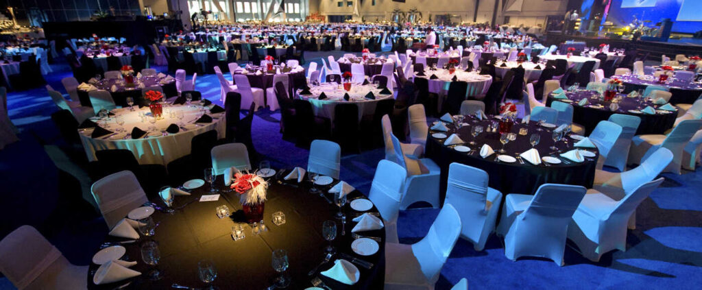 salle de réception avec de nombreuses tables éclairées de lumière bleu