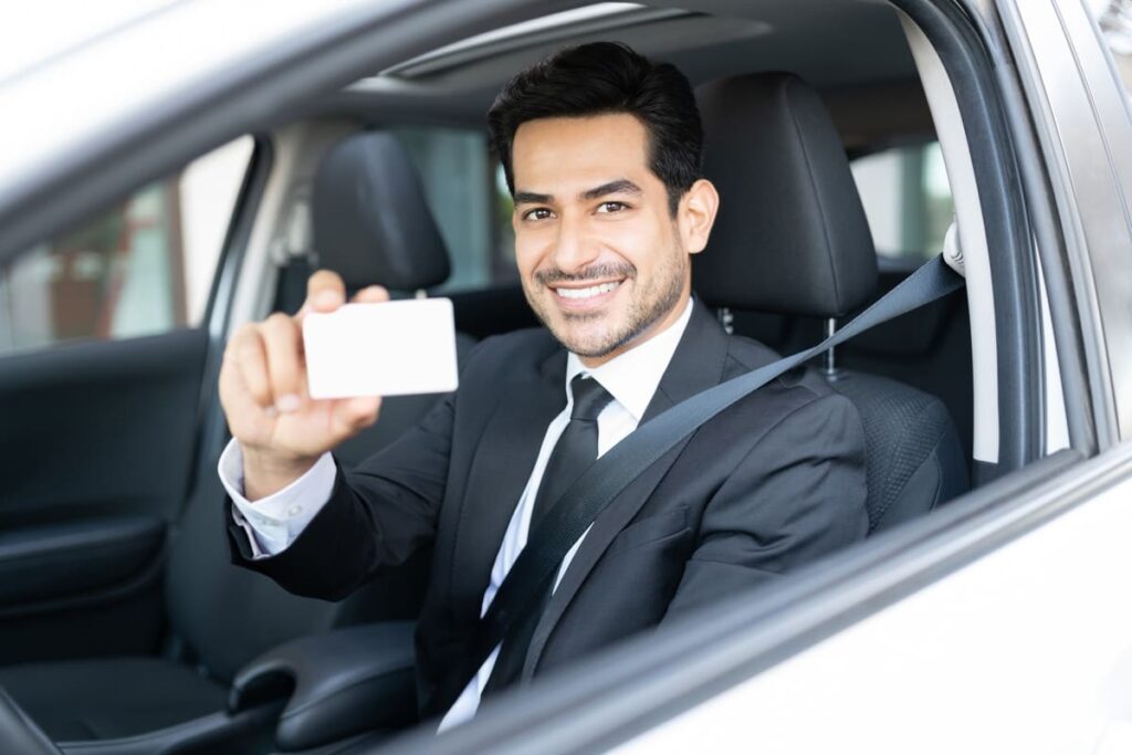 Chauffeur VTC montrant sa carte professionnelle a bord de son véhicule